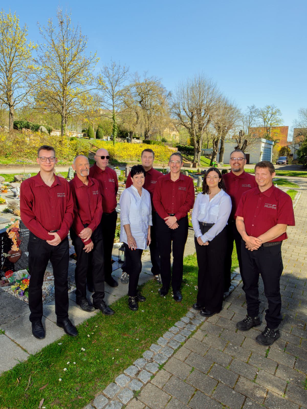 Team von Kuhn Bestattungen bei Sonnenschein auf dem Friedhof in Asperg