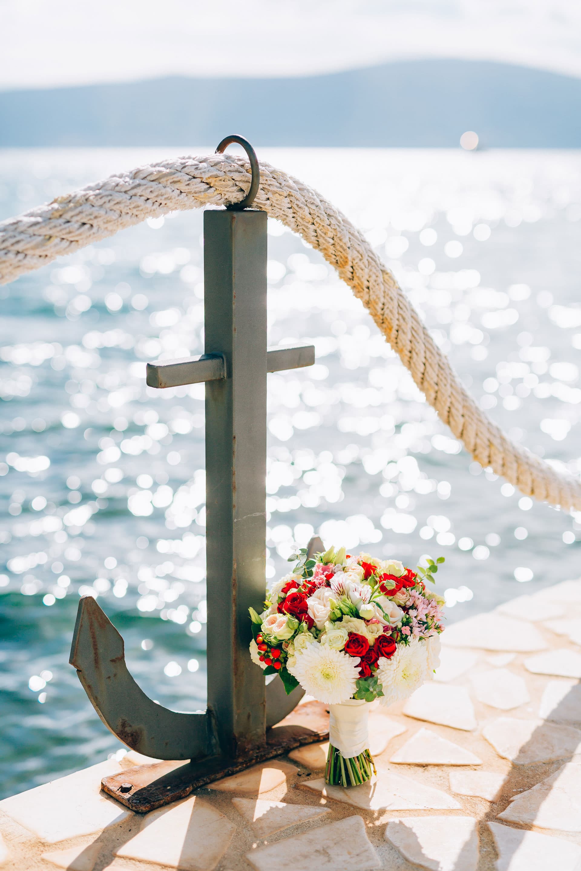 Anker mit Blumenstrauß am Ufer für eine maritime Seebestattung, Kuhn Bestattungen Asperg