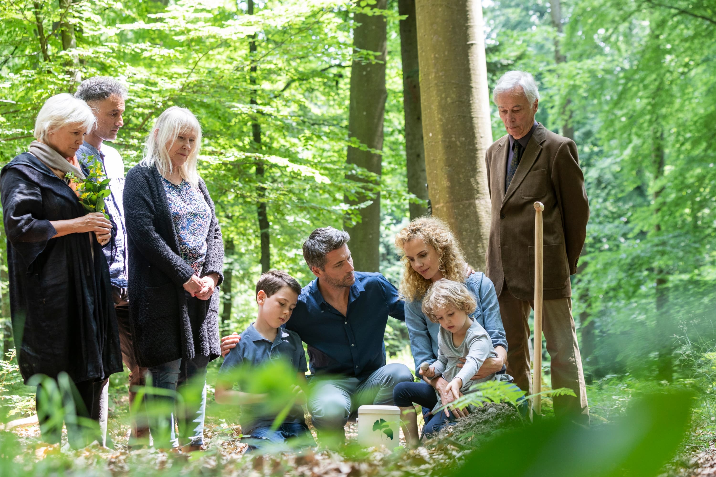 FriedWald-Bestattung - Naturverbundene Abschiedszeremonie Familie bei einer FriedWald-Bestattung, die Abschied von einem geliebten Menschen nimmt.