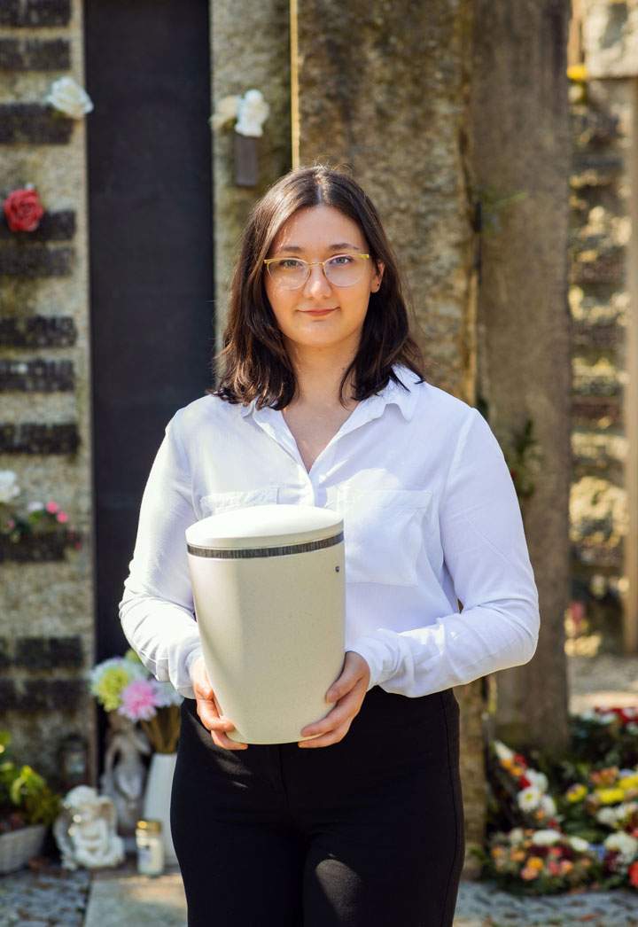 Despina Theodoru von Kuhnbestattungen Asperg hält eine Urne auf dem Friedhof
